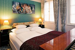 Doppelbettzimmer mit Fenstern und Blumenaktzenten